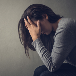 Woman depressed sitting with her head in her hands